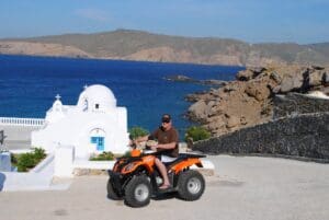 A man on an orange scooter and a view of the sea
