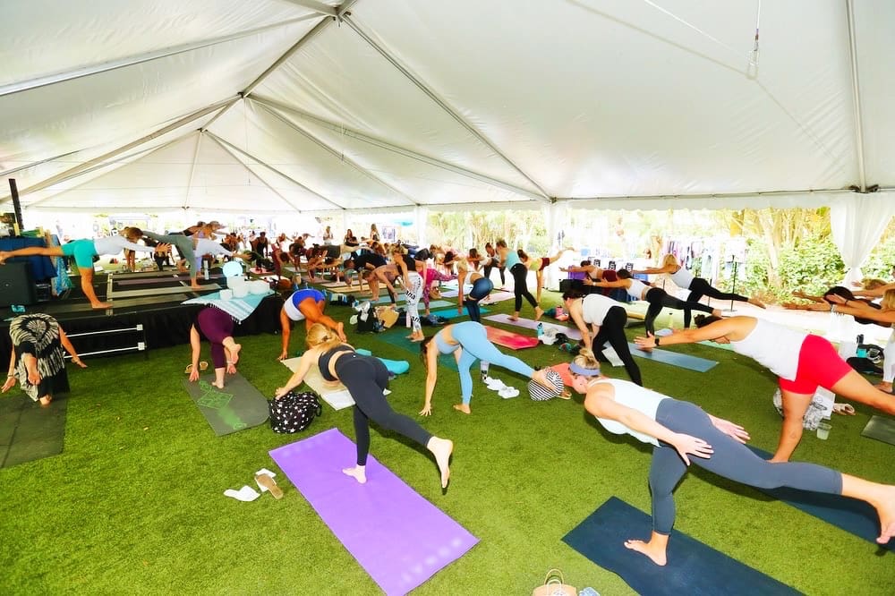 People doing yoga together in a big tent